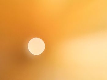 Low angle view of moon against orange sky
