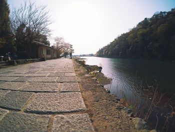 Footpath by river against sky