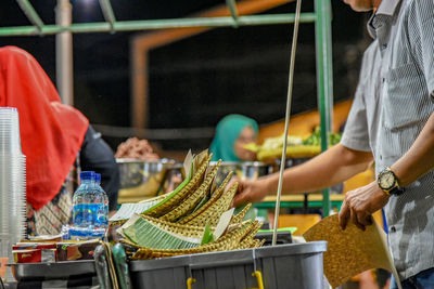 Midsection of standing at market stall