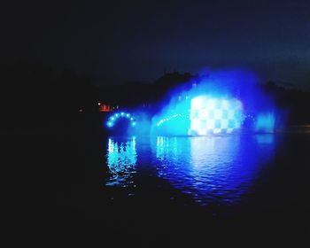 Reflection of illuminated lights in lake at night