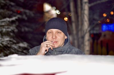 Young woman using mobile phone in snow