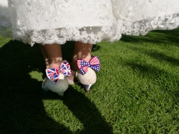 Low section of bride standing on grassy field