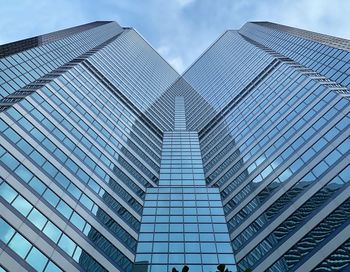 Low angle view of modern glass building against sky