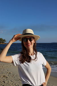 Portrait of young woman standing against sky