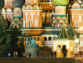 Close-up of people moving walking saint basils cathedral at night