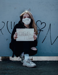 Portrait of girl with text against wall