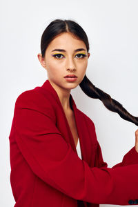 Portrait of young woman against white background