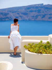Woman looking and enjoyed on amazing sea view on santorini island from terrace. santorini, greece.