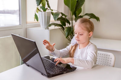 The girl learns, communicates, talks, through a computer / laptop