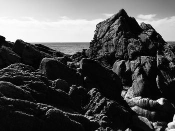 Scenic view of rocks on beach against sky