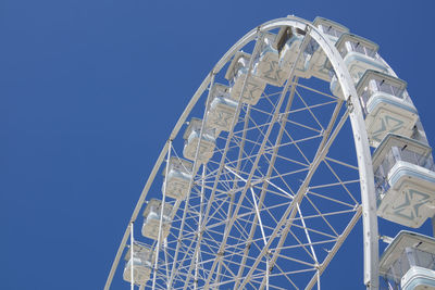 Low angle view of ferris wheel against blue sky