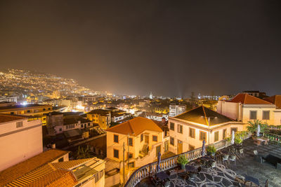 High angle view of illuminated buildings in city at night