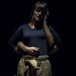 Young woman looking at camera against black background