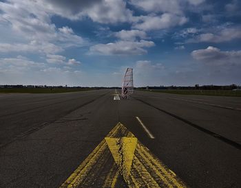 Road marking on airport runway against sky