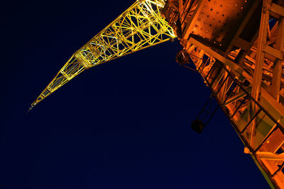 Low angle view of crane against sky at night