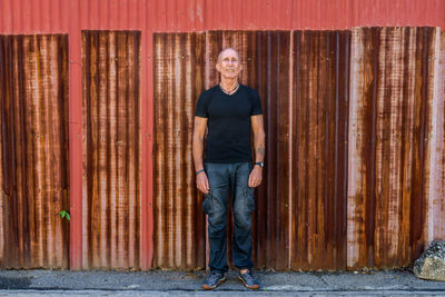Portrait of man standing against wall