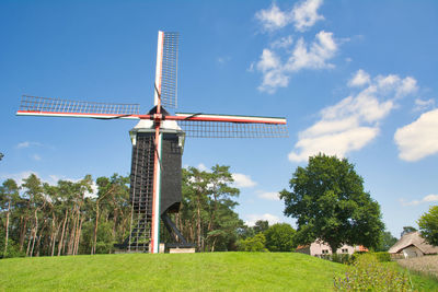 Traditional windmill on field against sky