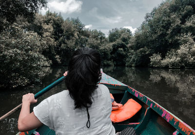 Rear view of woman on boat in lake