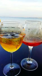 Close-up of beer in sea against sky