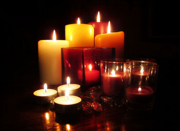 Close-up of lit candles and tea lights on table