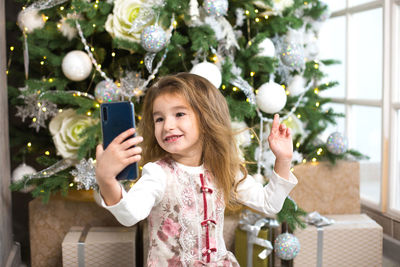 Portrait of girl holding christmas tree