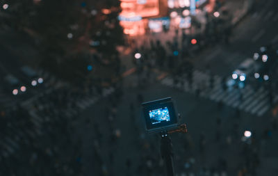 Camera on monopod over road in city at night