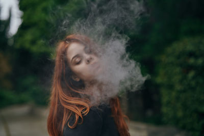 Young woman smoking outdoors