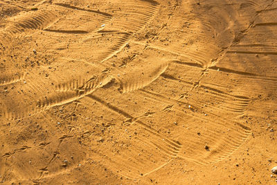 High angle view of tire tracks on sand