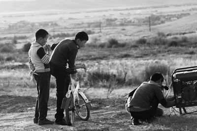 People standing on motorcycle on field