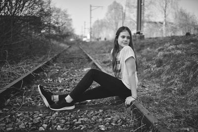 Portrait of a young woman sitting on land