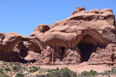 Rock formations against clear blue sky during sunny day