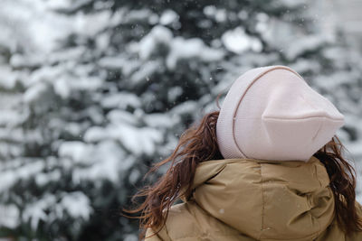 Happy middle age woman catching snowflakes in the city outdoors. relaxed emotional person walking in