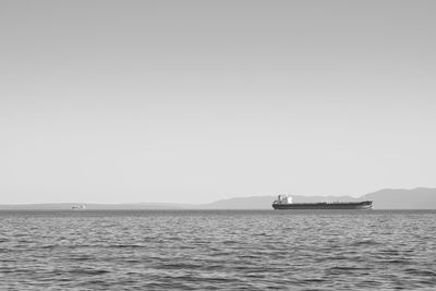 Sailboat sailing on sea against clear sky