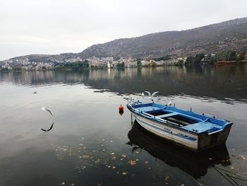 Boats moored in lake against sky