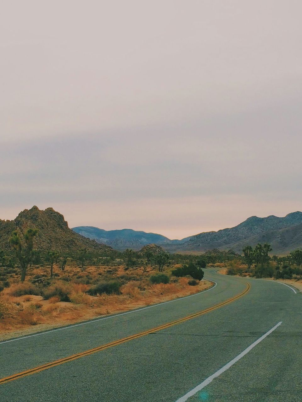 landscape, tranquil scene, mountain, road, tranquility, sky, scenics, beauty in nature, nature, mountain range, transportation, non-urban scene, cloud - sky, country road, remote, field, the way forward, horizon over land, idyllic, outdoors