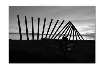 Empty chairs on field against sky