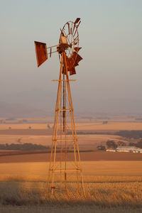 Low angle view of windmill on landscape against sky