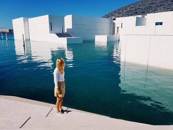 Rear view of young woman standing in swimming pool