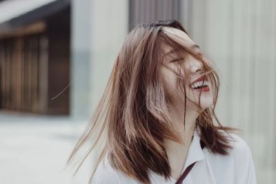 Cheerful smiling young woman standing outdoors