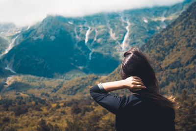 Rear view of woman standing at mountain