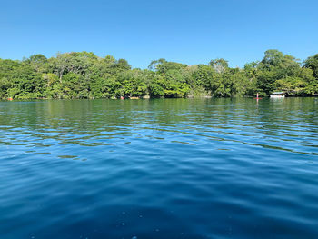 Scenic view of lake against clear blue sky