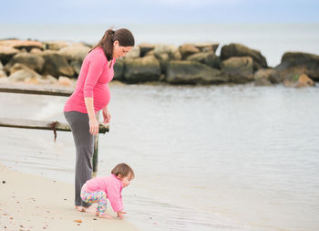 Rear view of young woman standing at beach