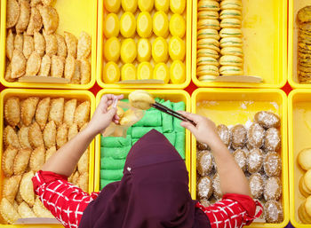 High angle view of woman picking food from basket at shop