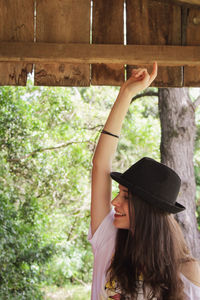 Rear view of young woman standing against window