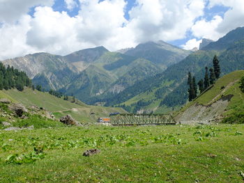 Scenic view of field and mountains against sky