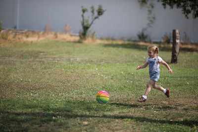 Boy playing with ball in grass