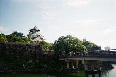 View of building by river against sky