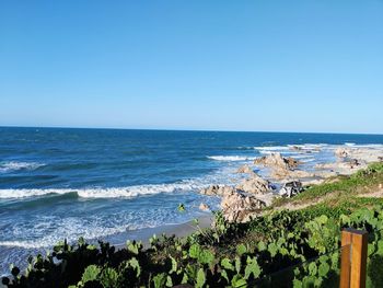 Scenic view of sea against clear blue sky