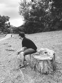 Side view of man sitting on field