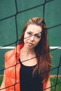 Portrait of woman with face paint seen through fence